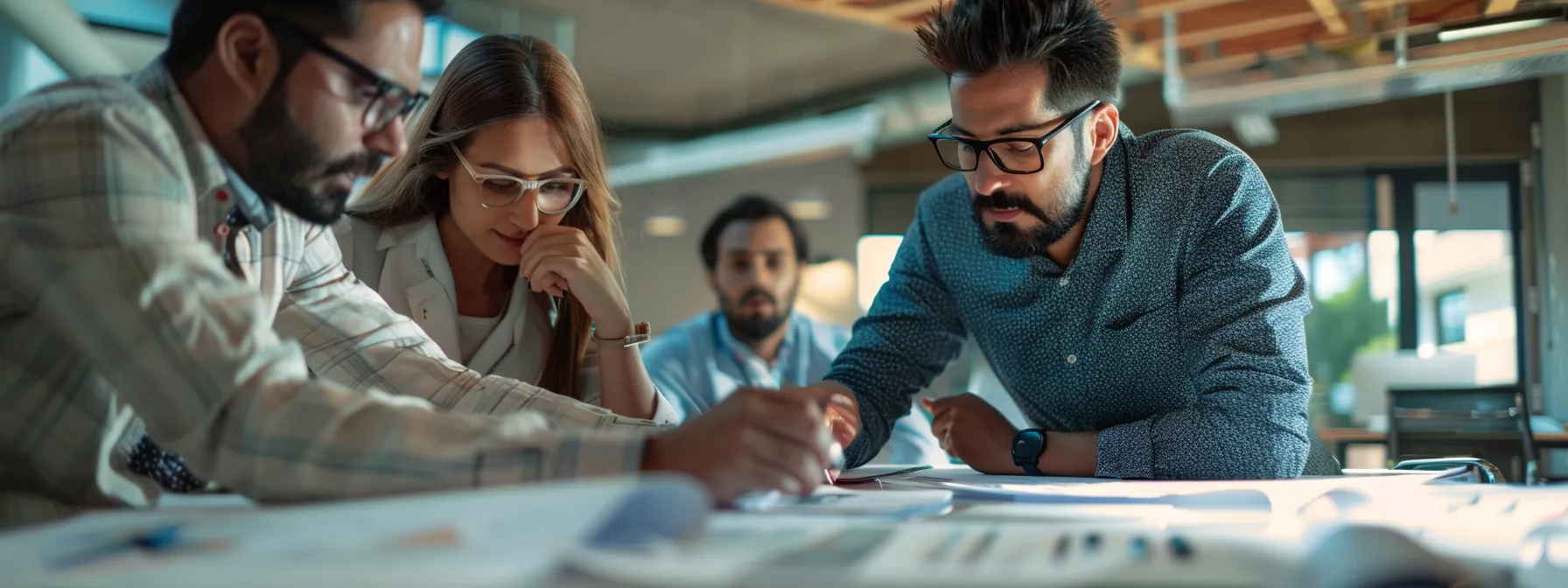 a group of business professionals discussing home additions in arizona while looking at architectural plans and design sketches.
